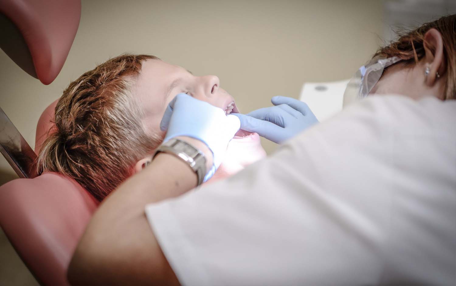 A young boy is getting a dental checkup.