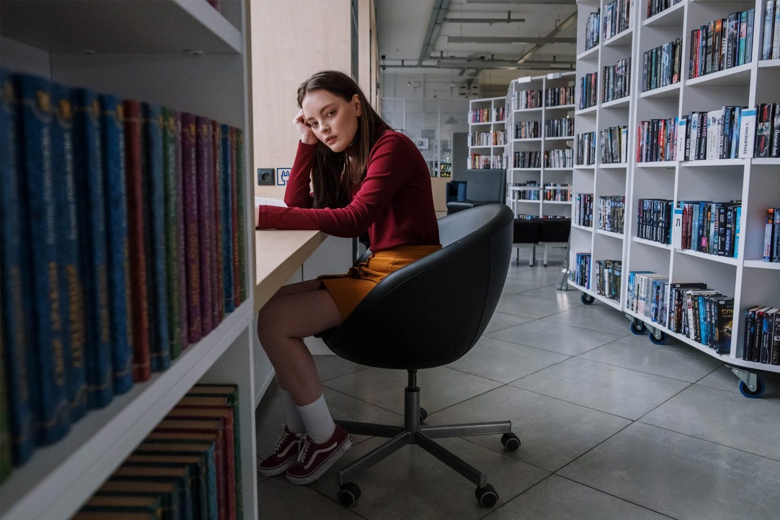 A girl sitting at a desk in a library.