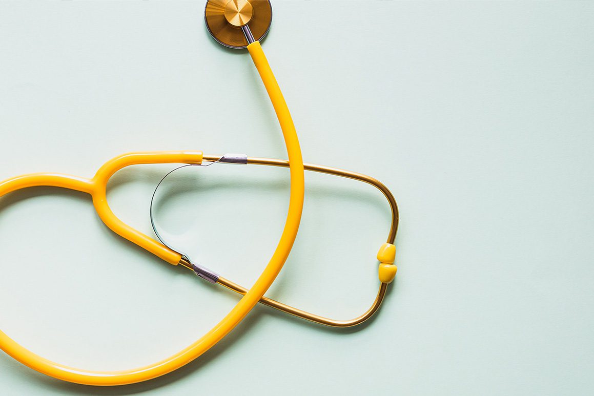 A stethoscope shaped like a heart on a blue background.