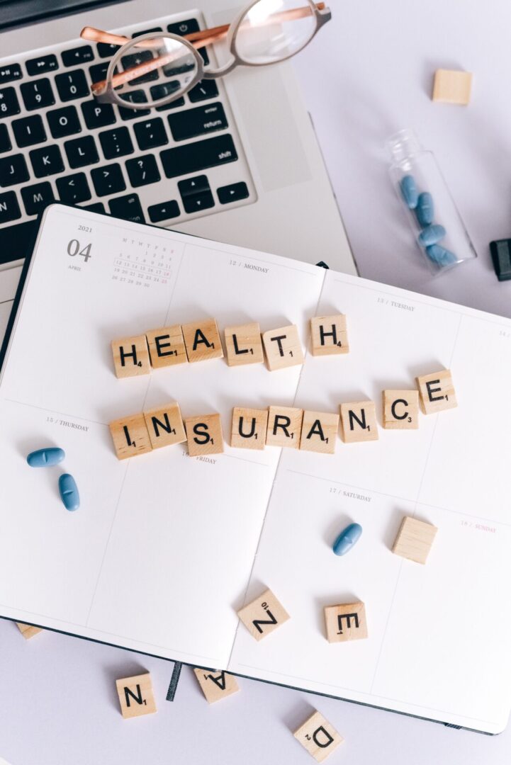A notebook with the word health insurance spelled out on it.