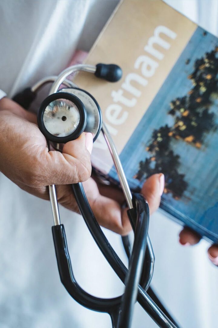 A doctor holding a book and a stethoscope.