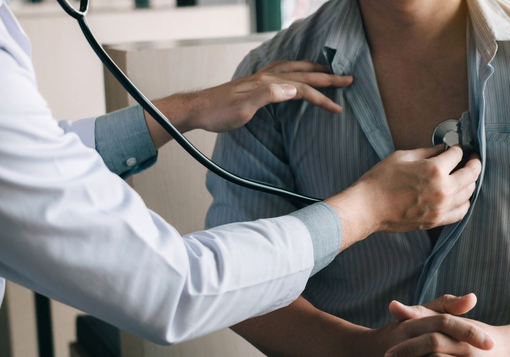 Doctor using a stethoscope to check a patient's heart.