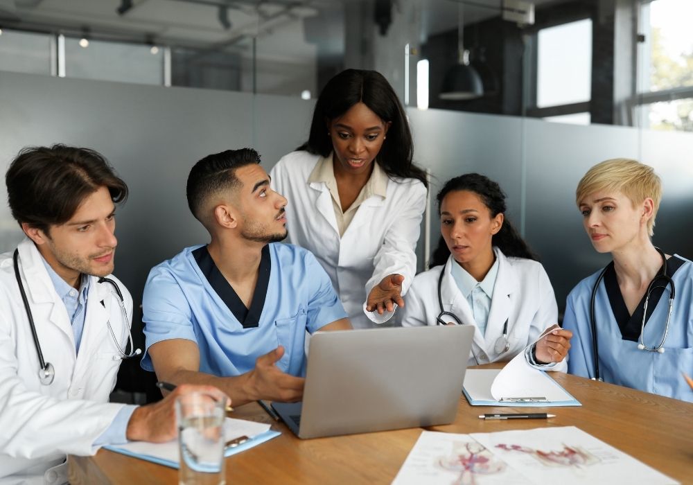Medical professionals discussing on a laptop.