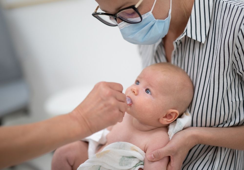 Woman feeding baby with a spoon.