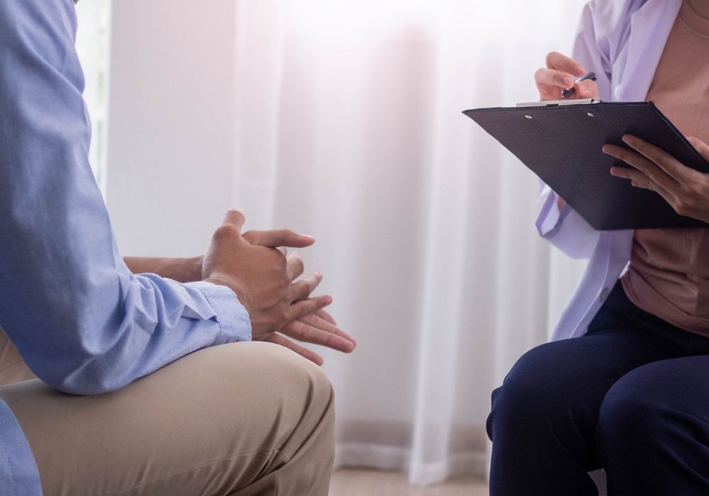 Person in a blue shirt talks to a therapist.