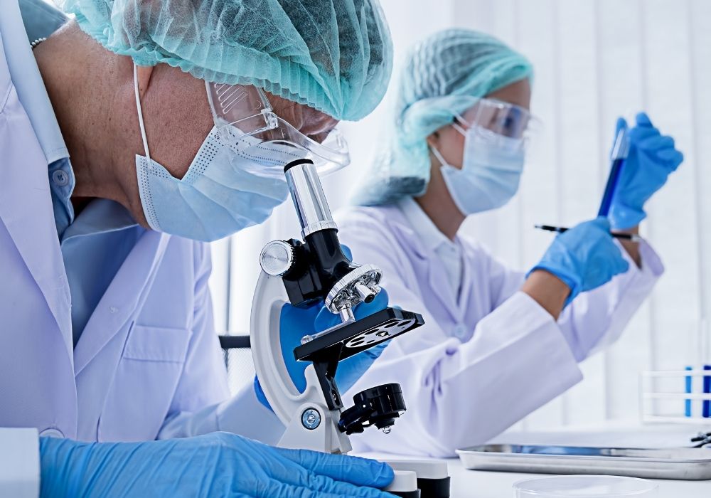 Scientist uses microscope in a lab.