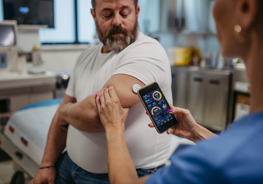 Doctor connecting continuous glucose monitor with smartphone, to check blood sugar level in real time