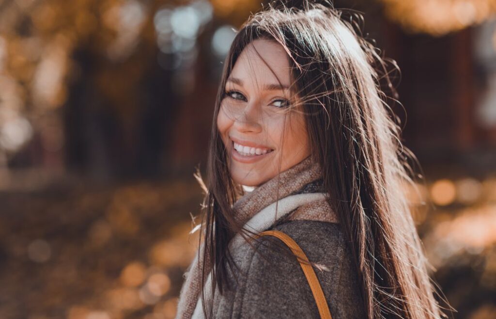 Cheerful woman walking in the fall park