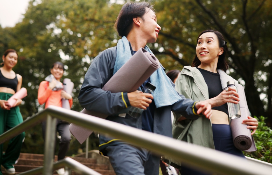 Walking, yoga and girl friends in nature with conversation for health, wellness and balance in morning. Stairs, talking and group of Japanese women outdoor for pilates workout or exercise in park