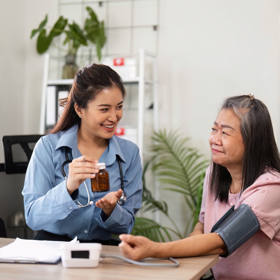 A nurse explains the importance of medication to an elderly patient, ensuring she understands her prescriptions and their uses in an informed consultation.