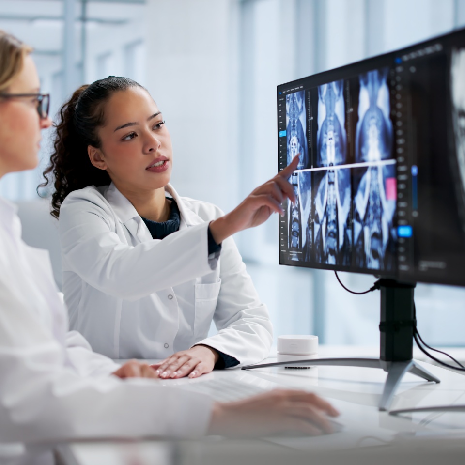 Female Radiologist Examining Spine MRI On Computer Screen In Hospital.