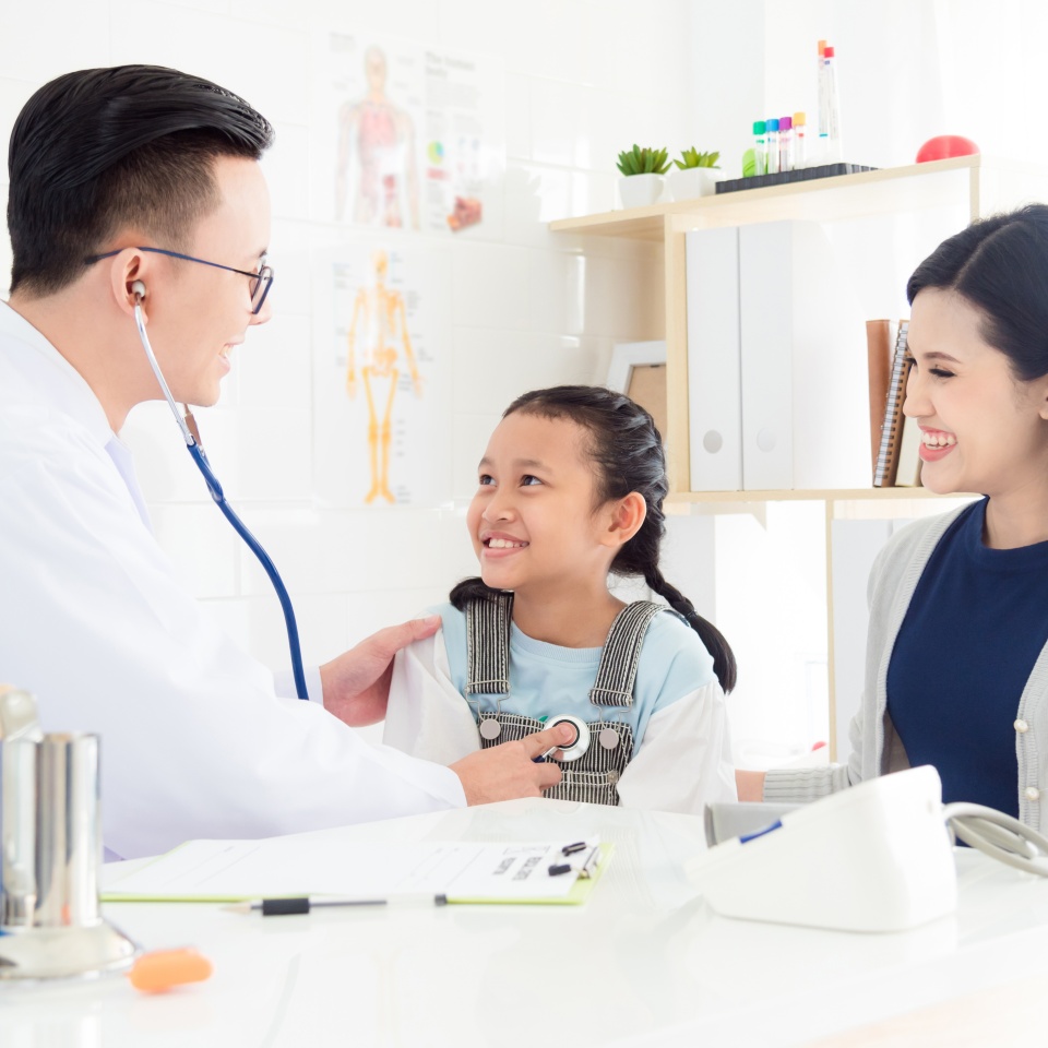 Asian doctor examining a girl by stethoscope ,mother sitting beside her daughter at hospital