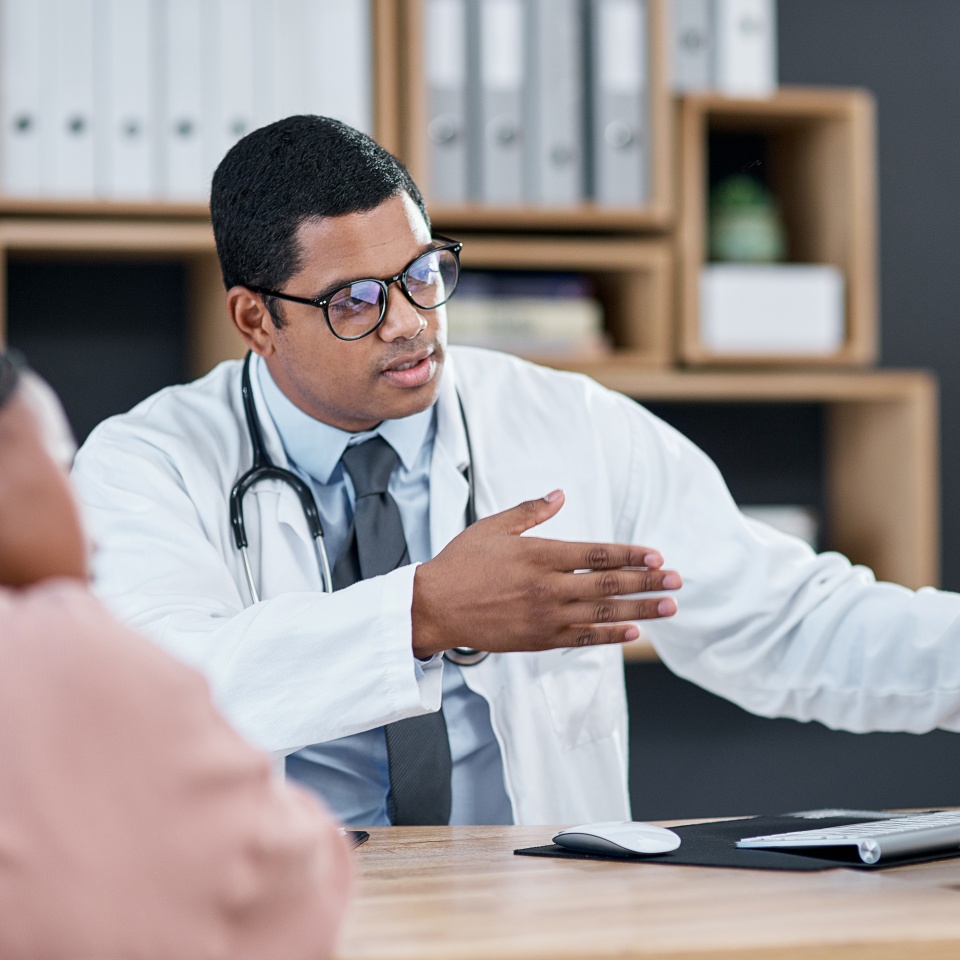 Shot of a doctor using a computer while having a consultation with a patient