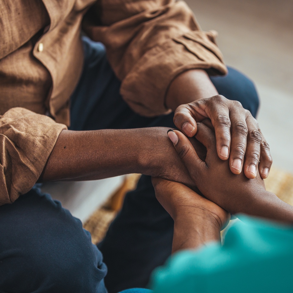 Closeup of a support hands. Closeup shot of a young woman holding a senior man's hands in comfort. Female carer holding hands of senior man