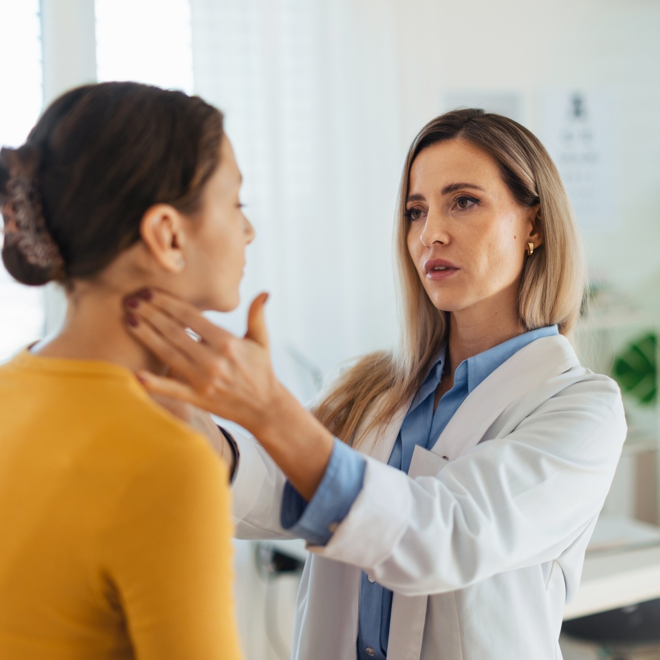 Doctor examining lymp nodes on neck of the teenage girl. Concept of preventive health care for adolescents.